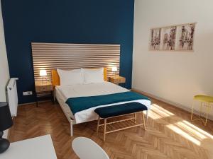 a bedroom with a bed with a blue wall at PIF Apartments Hirscher in Braşov