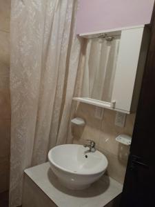 bagno con lavandino bianco e specchio di PACHA PUNKU a San Carlos