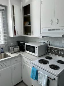 a kitchen with white cabinets and a stove top oven at Spotless 2 Bedroom Suite in Winnipeg in Winnipeg