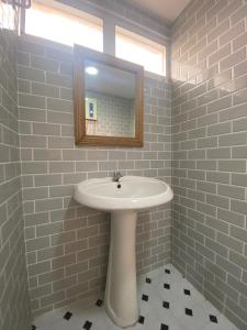 La salle de bains est pourvue d'un lavabo blanc et d'un miroir. dans l'établissement The Sky view on Nimman 12, à Chiang Mai