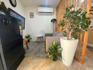 ein Wohnzimmer mit einem schwarzen Kühlschrank und einer Pflanze in der Unterkunft The Sky view on Nimman 12 in Chiang Mai