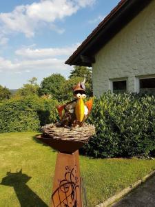 une statue d'un oiseau assis dans un panier dans l'établissement Ferienwohnung Vogelsang, à Loßburg