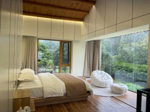um quarto com uma cama grande e uma janela grande em Yangshuo Vivian Villa em Yangshuo