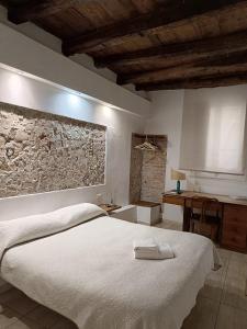 a bedroom with a white bed and a stone wall at AL183 in Cagliari