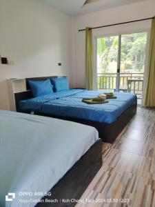 2 łóżka w pokoju hotelowym z oknem w obiekcie Yuyu Golden Beach w mieście Ko Chang