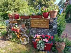 a sign with a bunch of flowers and a bicycle at Le Moulin de Pensol in Pensol