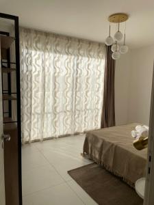 a room with a bed and a window with a curtain at Blu Mar Sea View Apartments in St. Paul's Bay
