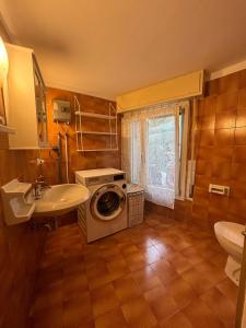 y baño con lavadora y lavamanos. en PM 48 Viale Ugo Foscolo Guest House, en Toscolano Maderno