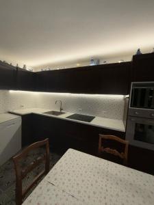 uma cozinha com um lavatório, uma mesa e cadeiras em PM 48 Viale Ugo Foscolo Guest House em Toscolano Maderno