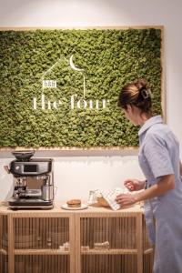 B&B The Four في ميشيلين: امرأة تقف بجوار طاولة مع آلة صنع القهوة