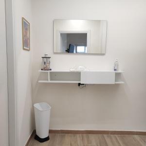 La salle de bains est pourvue d'un lavabo blanc et d'un miroir. dans l'établissement Onda marina 1, à La Spezia
