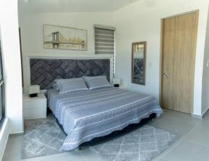 ein Schlafzimmer mit einem großen Bett und einer Holztür in der Unterkunft Casa Campestre - Aeropuerto Amuray en el aeropuerto el Edén in La Tebaida
