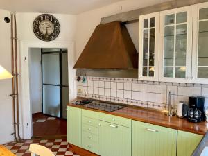 a kitchen with green cabinets and a clock on the wall at Art-be-and-b Appartement -Studios in Riegel am Kaiserstuhl