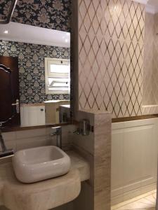 a bathroom with a sink and a mirror at ALMADIAFAH APARTMENT - المضيفة للوحدات الفندقيه in Mansoura