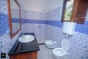 y baño con aseo, lavabo y espejo. en Sri Lanka villa DSR , Wennappuwa, en Wennappuwa