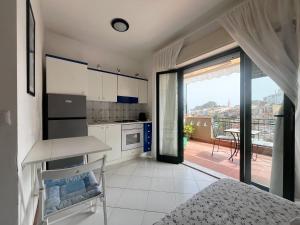 une cuisine blanche avec vue sur un balcon dans l'établissement Suite Gardenia, à Taormine