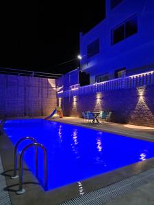 a swimming pool at night with blue lighting at Amazing Villa With Large Private Swimming Pool in Tangier