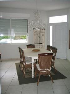 comedor con mesa blanca y sillas en Grande maison 40m de la plage de Pontaillac, en Royan