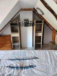 ein Schlafzimmer im Dachgeschoss mit einem Bett und Regalen in der Unterkunft Villa 3 chambres piscine Croatie in Donje Makojišće