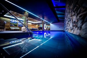 una piscina con luci blu in una casa di Hôtel de Rougemont & Spa a Gstaad