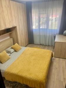 una camera da letto con un letto con una coperta gialla sopra di Fortress View a Rîşnov