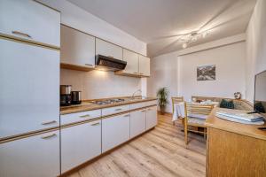 a kitchen with white cabinets and a dining room at Josefsheim in Lana