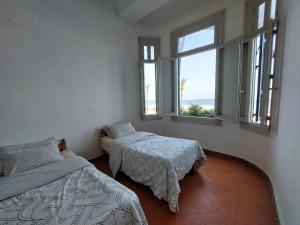 1 dormitorio con 2 camas y 2 ventanas en Alexandria private rooms at Shared apartment, Only Men Guests 仅限男士 en Alexandría