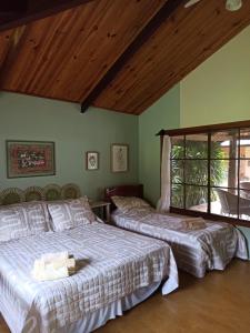 a bedroom with two beds and a window at Chalés Pássaros do Cerrado in Cavalcante