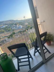 2 Stühle und ein Tisch auf einem Balkon mit Aussicht in der Unterkunft Mellieha Apartment in Mellieħa