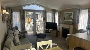 a living room with a couch and a television at Dog Friendly Lodge with hot tub Quiet Location in Great Eccleston