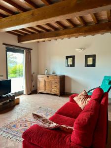 a living room with a red couch and a tv at Villa Castagnone in Agna
