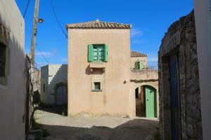 an old building with a green window in an alley at Axion Studios in Aroniadika
