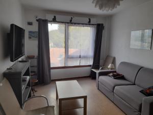 sala de estar con sofá y ventana en Vacances Xonrupt-Gerardmer, en Xonrupt-Longemer
