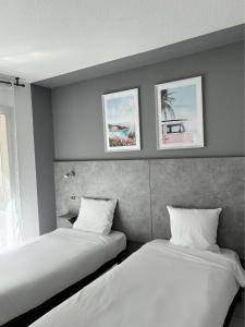 twee bedden naast elkaar in een kamer bij Acapella Hotel in Argelès-sur-Mer