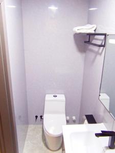 uma casa de banho com um WC branco e um lavatório. em Starry Beach Inn em Hulhumale