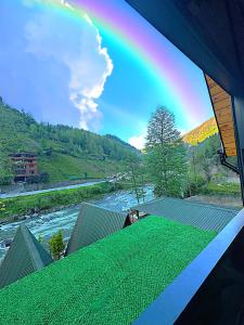 ein Regenbogen vom Dach eines Hauses aus gesehen wird in der Unterkunft Tabiat Bungalows in Çamlıhemşin