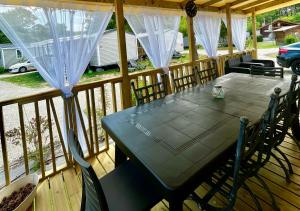 a screened in porch with a table and chairs at Au Ferret plage,piscines à 2 pas en famille by Vayny in Lège-Cap-Ferret