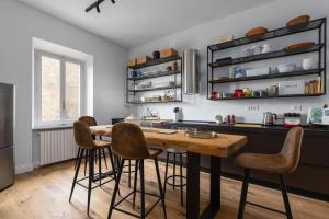 a kitchen with a wooden table and bar stools at Dimora San Donato in Casole dʼElsa +27 photos