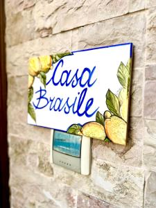 een bord op een stenen muur met een bord dat salsa mand leest bij Casa Brasile in Vico Equense