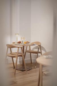 uma mesa de madeira e cadeiras num quarto em B&B The Four em Mechelen