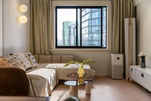 a living room with a couch and a window at Shanghai Downtown YD B&B - Near Jing'an Temple Subway and Bund in Shanghai