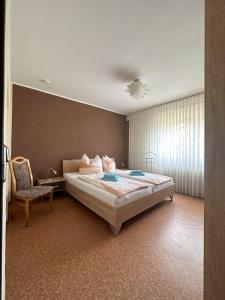 1 dormitorio con 1 cama grande y 1 silla en Ferienwohnung Noll en Alzenau in Unterfranken