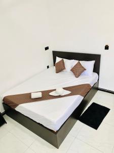 een slaapkamer met een groot bed en 2 handdoeken bij SSS HOTEL in Trincomalee