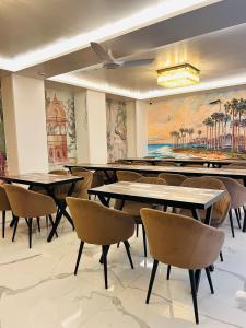 a dining room with tables and chairs and a painting at Raksha Suites & Banquet Greater Noida in Greater Noida