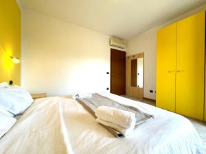 Un dormitorio con una cama blanca con toallas. en Smeraldo Retreat, en Peschiera del Garda