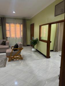 een woonkamer met een bank en een stoel bij Winnie's Home in Morogoro