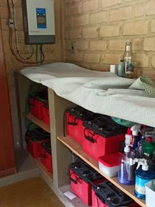 a table with red tool boxes on a shelf at Chalés Pássaros do Cerrado in Cavalcante