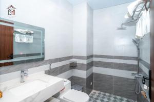 uma casa de banho com um lavatório, um WC e um chuveiro em Chuly Moon Motel em Hà Tiên