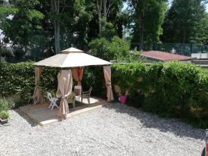 eine Holzterrasse mit einem Sonnenschirm und Stühlen in der Unterkunft Glycine in Le Petit-Quevilly