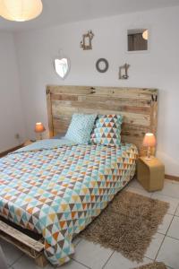 Schlafzimmer mit einem Bett mit einem Kopfteil aus Holz in der Unterkunft Glycine in Le Petit-Quevilly